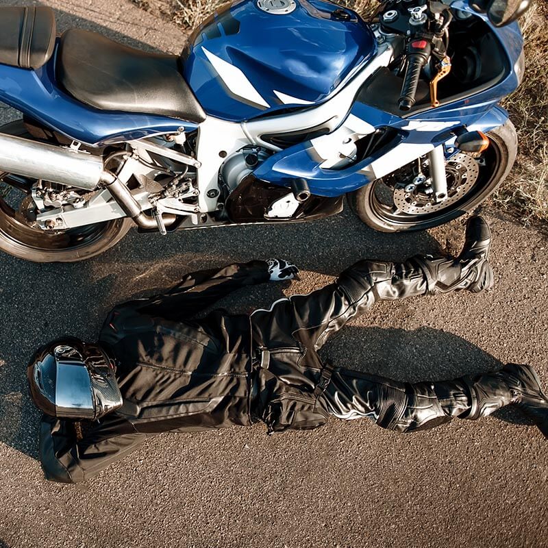 Gilbert Law Firm - Reputable Motorcycle Accident Attorney Rockford WA - Wrecked Motorcycle with Rider Down